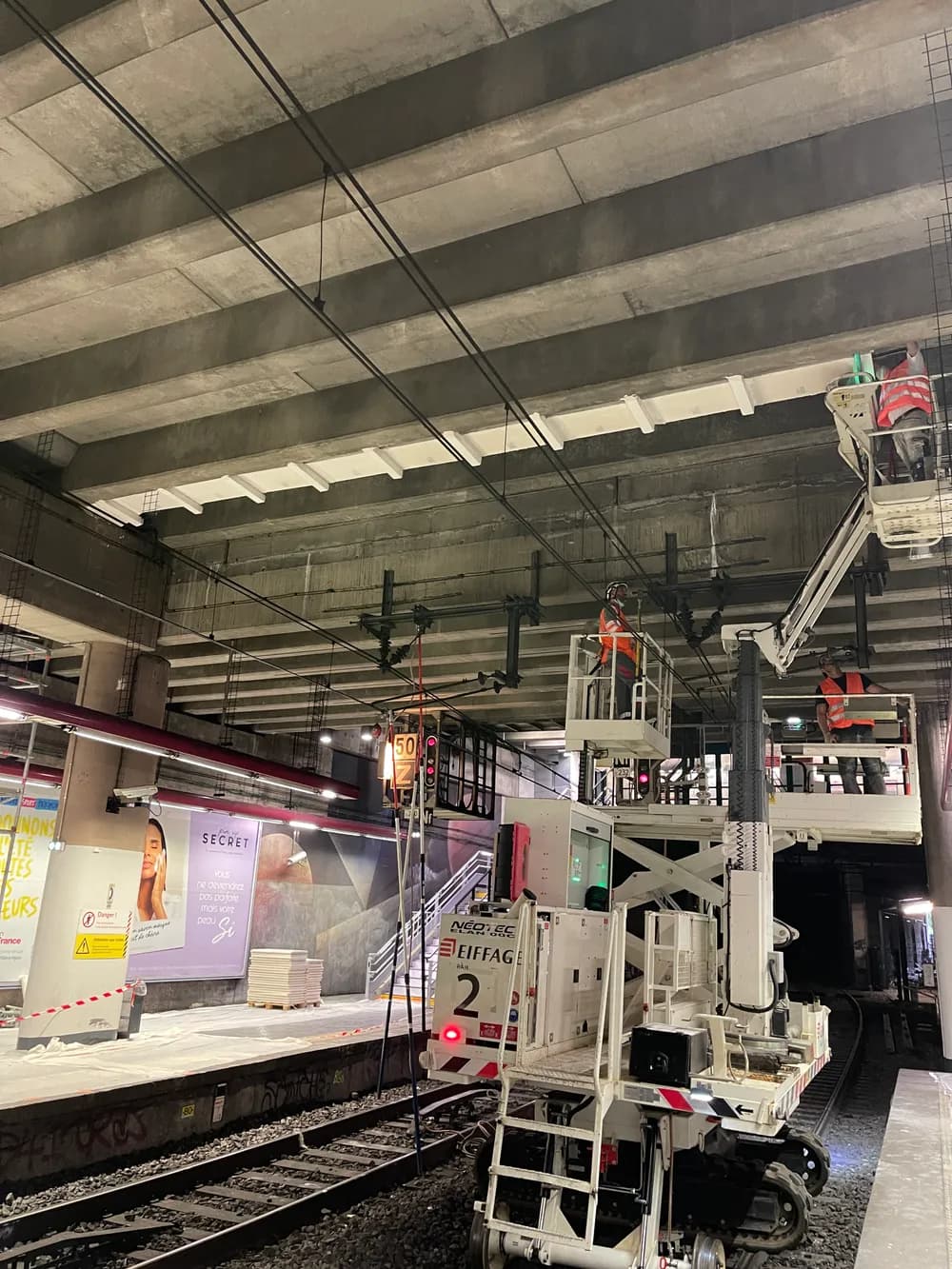 Opérateur en nacelle posant des gaines en staff — Gare Pereire Levallois